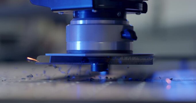 Close-up of automated CNC deburring machine processing edges of a metal component