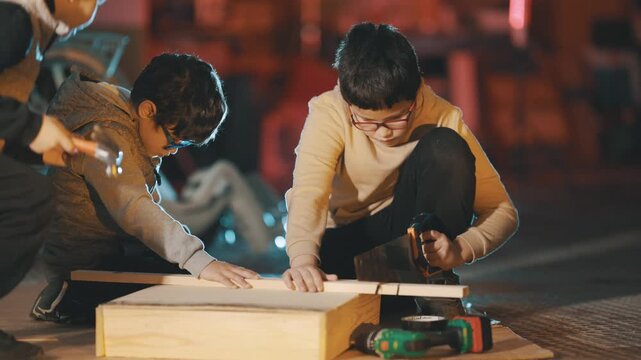 Young boys building together in a woodworking workshop
