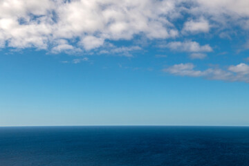 Spokojny horyzont oceanu pod błękitnym niebem z chmurami © Kamil_k2p