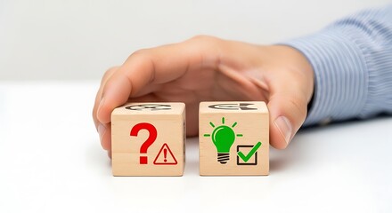 Hand holding blocks with question mark and light bulb symbols representing problem solving and idea generation