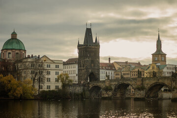 Fototapeta premium Old Town Bridge Tower and Charles Bridge in Prague. Historic gothic architecture above Vltava river under cloudy sky. Iconic Czechia landmark for travel, history and European culture related projects.