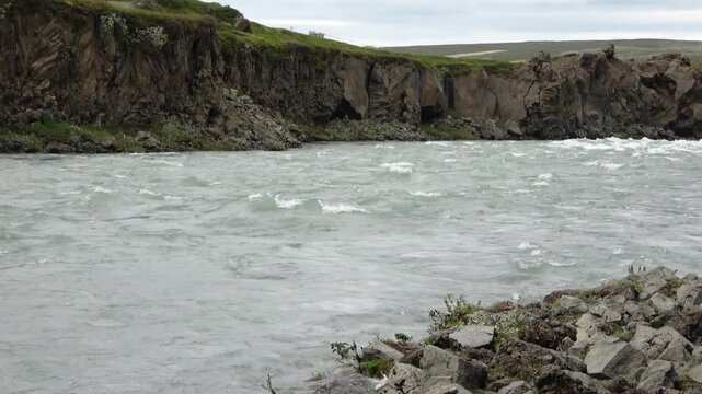 Wild river flowing through Icelandic basalt rock canyon