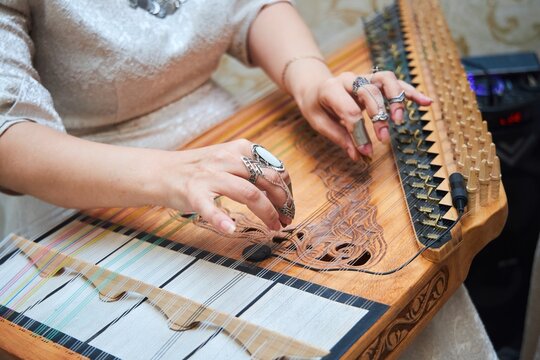 The Armenian national stringed instrument Qanun. Women's hands are playing an instrument.