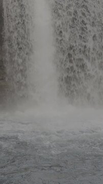 Hermosa cascada ancha fluyendo hacia un r&iacute;o turquesa en paisaje natural