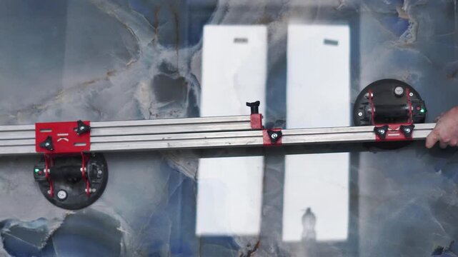 Master tilers carry a huge large-format tile of XXL size. Professional vacuum tile transport. Professional tile work, bathroom renovation, laying blue tiles, slow motion