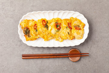  동태를 얇게 썰거나 다져 양념을 한 뒤, 밀가루와 달걀을 입혀 기름에 지진 음식.
A dish made by thinly slicing or mincing pollack, seasoning it, coating it in flour and egg, and then frying it in oil.