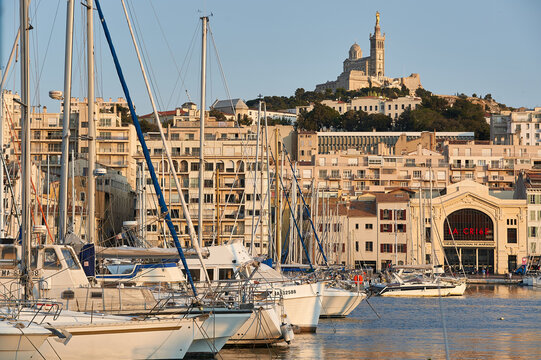 Wide view of the Old Port marina featuring the La Criee theater facade and Notre-Dame de la Garde on the horizon, Marseille, Provence-Alpes-Cote d'Azur, France