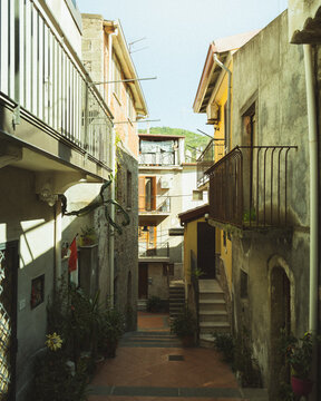 Graniti, Italy - 11 April 2025: View of a narrow alleyway where aged buildings rise, their weathered walls creating a textured tapestry of urban life.