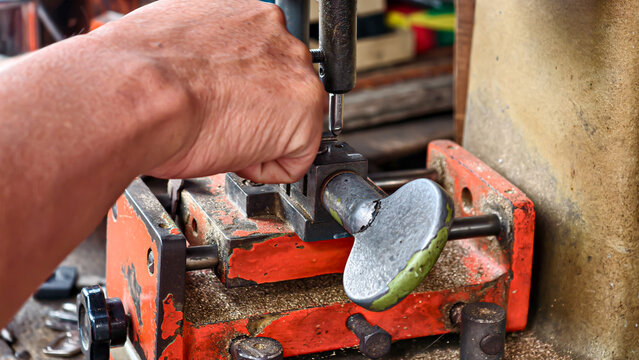 Skilled hands precisely duplicating a key on a specialized duplication machine, highlighting locksmith services and key cutting expertise