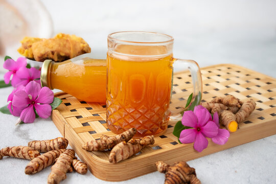Indonesian herbal drink for health, or jamu called kunyit asam, made with turmeric, palm sugar, and tamarind; served in a glass or bottle.