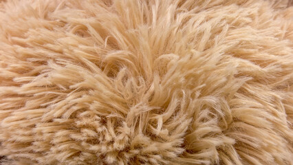 Fototapeta premium Intricate close-up of a soft, shaggy light brown textile, highlighting its fluffy texture and inviting warmth, perfect as an abstract background or cozy element