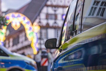 Police Cars at Public Festival German patrol vehicles securing evening event with festive lights © REHMEDIA | Ray Heese