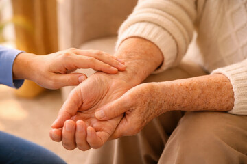 Elderly care senior healthcare aging population caregiver support gentle touch hand comfort trust compassion in warm home setting nurturing bond emotional connection
