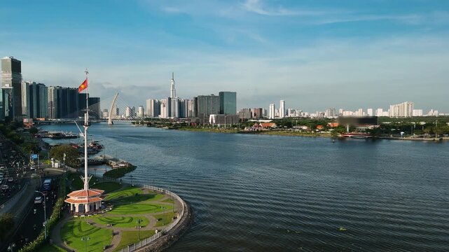 Aerial view of ho chi minh city skyline with the saigon river and vietnamese flag flying over bach dang wharf park