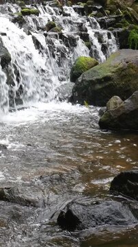 Clear mountain water moving across rocks with scenic depth and natural light. Designed for Vertical digital advertising and outdoor visual content.