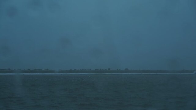 車の窓に落ちるみぞれ交じりの雨