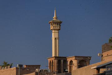 Obraz premium Views of Oriental buildings, sandstone walls and arches, windows and doors. On the streets of Dubai, in a public place.