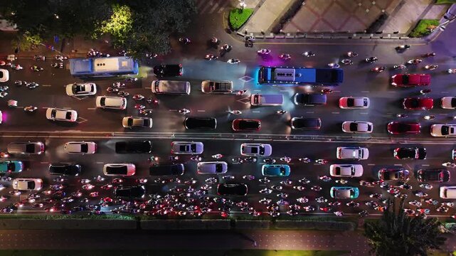 Top down aerial view of night traffic in ho chi minh city, vietnam. Hundreds of cars, buses, and motorbikes with headlights on