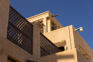 Views of Oriental buildings, sandstone walls and arches, windows and doors. On the streets of Dubai, in a public place.