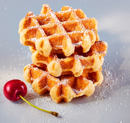 Miniwaffeln mir Puderzucker und Kirsche