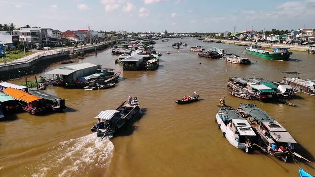 Traditional floating market on the mekong river in vietnam with people trading on boats, cai rang floating market an aerial view