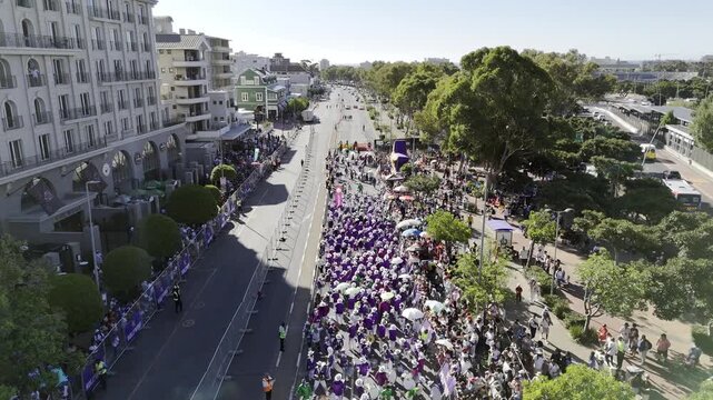 Drone flies with parade as it progresses down Main Street during Cape Town Minstrels Carnival on sunny afternoon in Green Point, South Africa