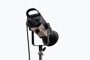 A professional studio spotlight stands on a whit background.