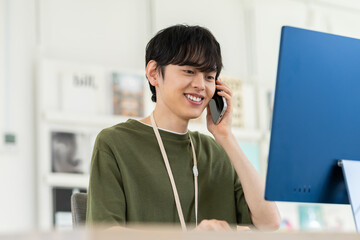 オフィスで電話する若い男性のエンジニア