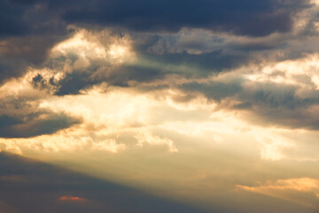 Obraz premium dramatic cloudy sky in warm evening glow. moody meteorology background for stormy weather forecast. spiritual cumulonimbus cloudiness during spring. golden brilliance through sunset sky