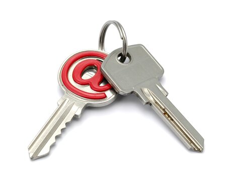 Two metallic keys on a white surface, one with a red "@" symbol for internet