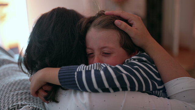 Mother comforting crying child in emotional embrace, hands holding gently, expressing love, protection, and care, family support during distress, close-up intimate moment