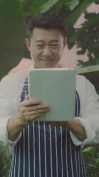 Modern small scale farming business professional manages inventory through digital tools in greenhouse environment