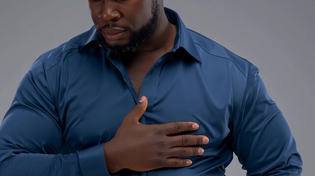 Man blue shirt hand chest chest pain concern portrait empathetic sincere gesture showing discomfort and thankful confident posture isolated gray