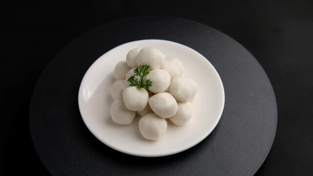 Uncooked Thai Pork meatballs on white plate.