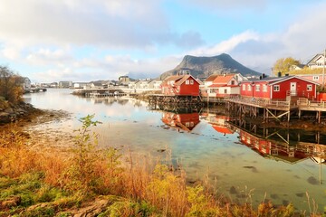 Svolvær waterfront cabins reflected on calm arctic water, Lofoten islands, Norway © Connie