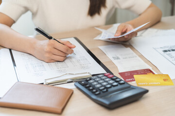 Naklejka premium Deduction planning, debt asian young woman calculating money balance of finance from bill and income, cost budget expenses for pay money form personal individual on table at home. Financial concept.
