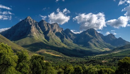 Obraz premium Mountain range panorama, lush valleys, vibrant greenery, sunny day