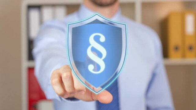 Businessman pointing at glowing legal protection shield symbol in office environment