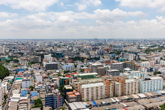 Panoramic view of Bangkok city skyline and urban landscape in Ratchada district under a bright blue sky, Thailand.