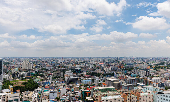 Panoramic view of Bangkok city skyline and urban landscape in Ratchada district under a bright blue sky, Thailand.