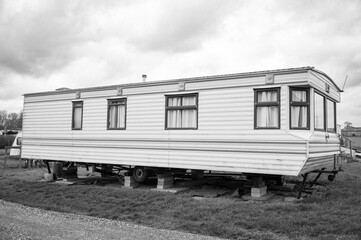Fototapeta premium photo of a old caravan on block old trailer park black and white 