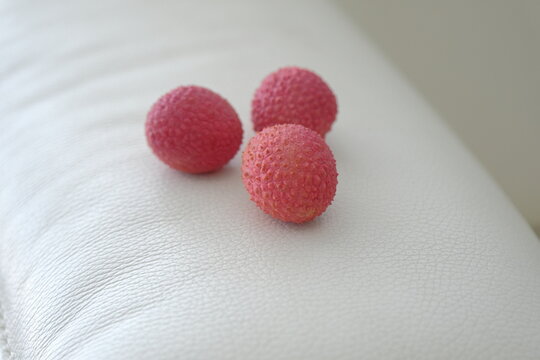 lychee fruit. red lychee fruit on a white plate. lychee is a small tropical fruit from the soapberry family
