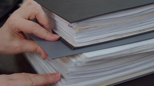 Hands adjusting stack of office documents