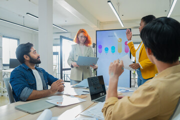 Obraz premium Professionals brainstorming marketing strategy around conference table, analyzing performance charts, teamwork communication, corporate planning meeting, office collaboration.