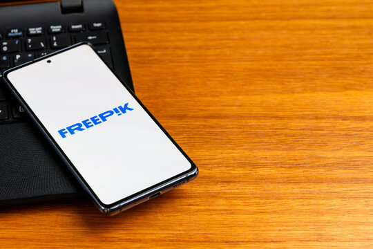 Punta Arenas, Chile &ndash; February 23, 2026: The Freepik digital content platform logo displayed on a smartphone screen resting on a laptop keyboard