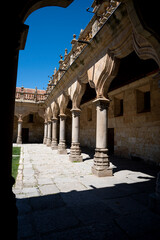Fototapeta premium Stone columns in a sunny courtyard with blue sky.
