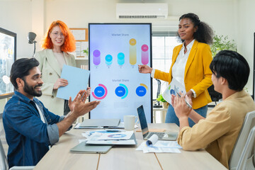 Diverse coworkers discussing analytics presentation in bright workspace, teamwork planning,...