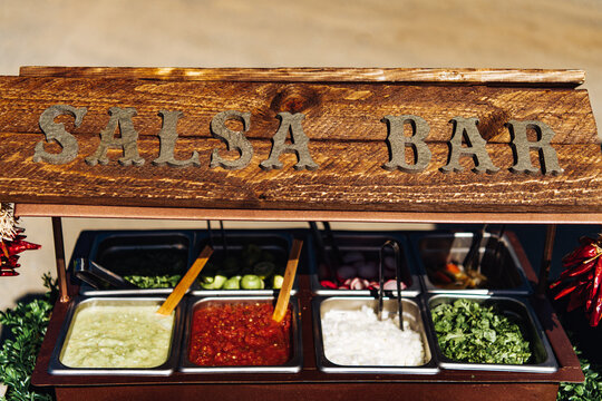 Salsa Bar with metal trays of taco condiments