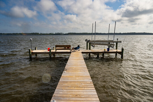 A man lounges on a folding chair on a wooden dock in Pamlico Sound, North Carolina