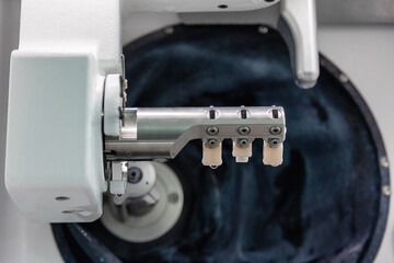 Close-up of dental CAD CAM milling machine creating ceramic restorations. High-precision equipment used in modern dental laboratory for crowns and prosthetics production. © Tatiana
